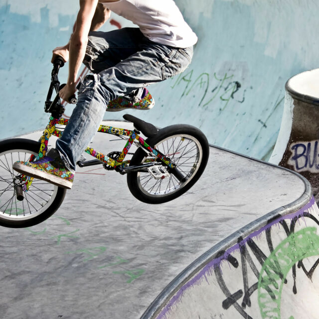Radfahrer auf buntem BMX Rad mit passenden bunten Schuhen in Saktepark